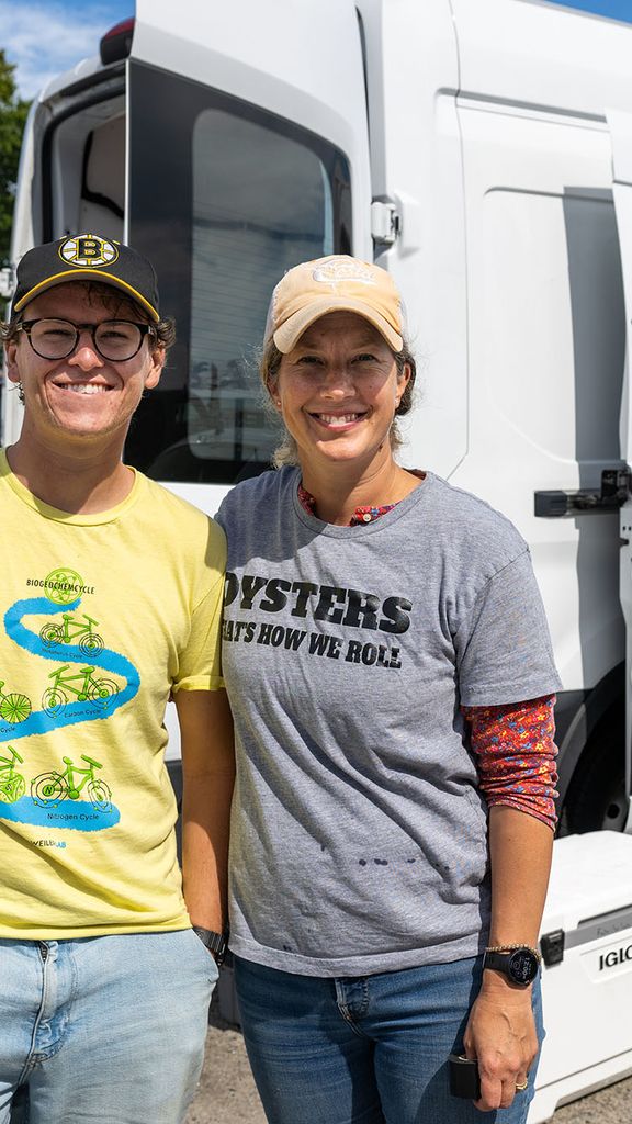 Photo: Two people smiling in front of the PEARL mobile oyster lab van