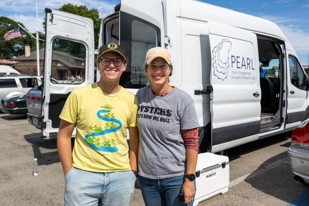 Photo: Two people smiling in front of the PEARL mobile oyster lab van