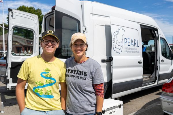 Photo: Two people smiling in front of the PEARL mobile oyster lab van