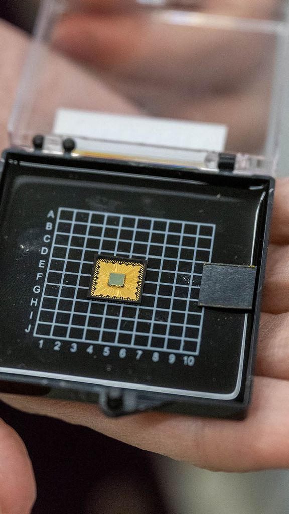 Photo: A hand holding a case with a small engineering chip inside.