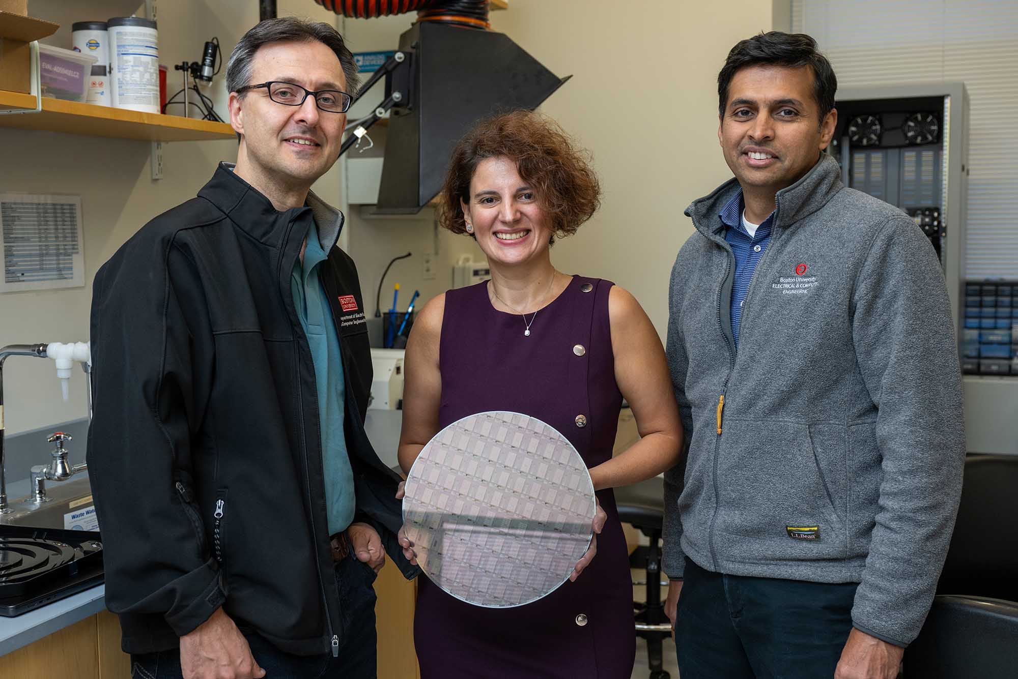 Photo: A group shot of three researchers holding a micro chip disk and smiling for the photo.