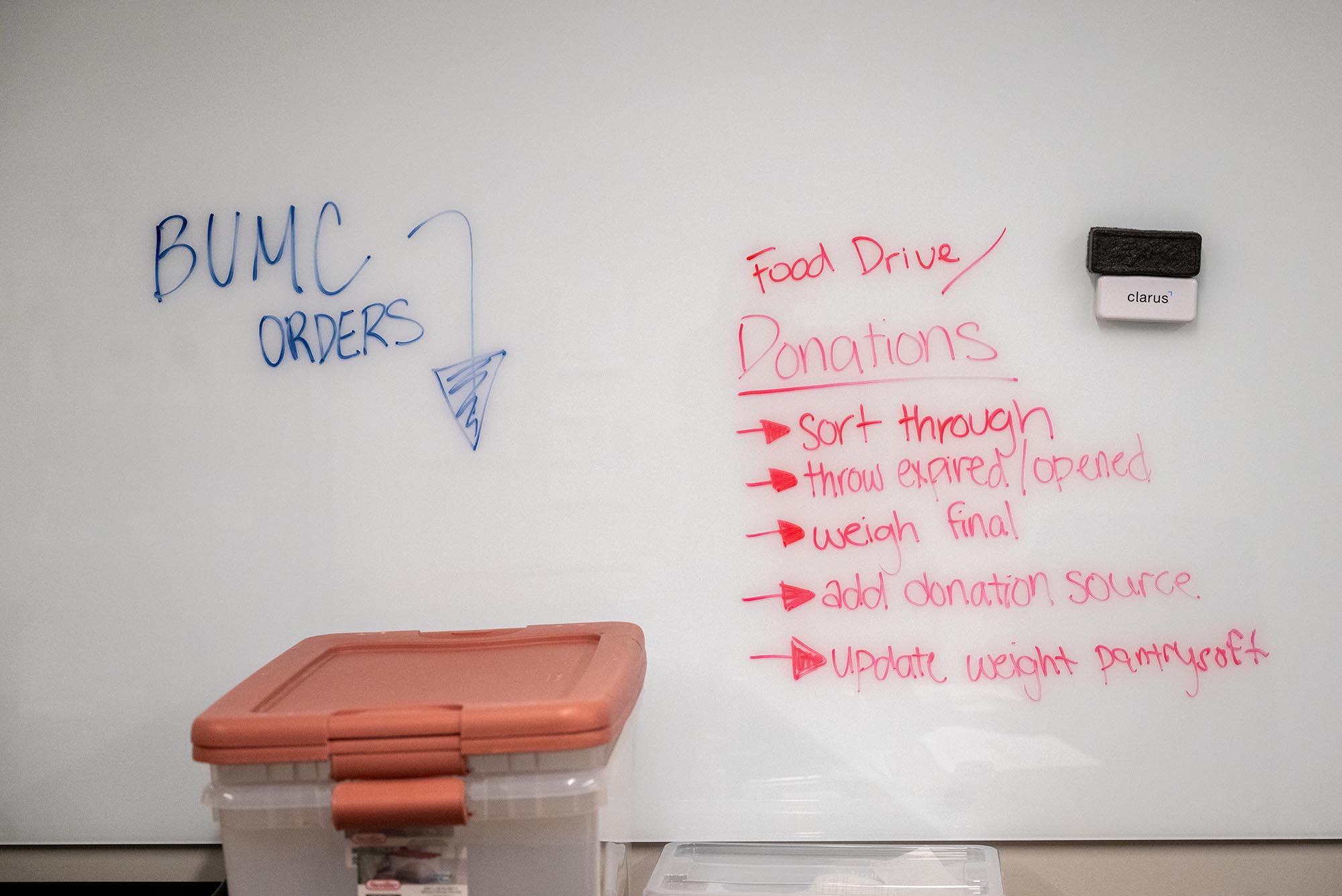 Photo: A dry erase board with instructions on where to place BUMC orders and donations.