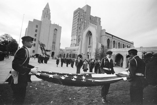 Photo: A black-and-white photograph of BU ROTC members carrying an American flag