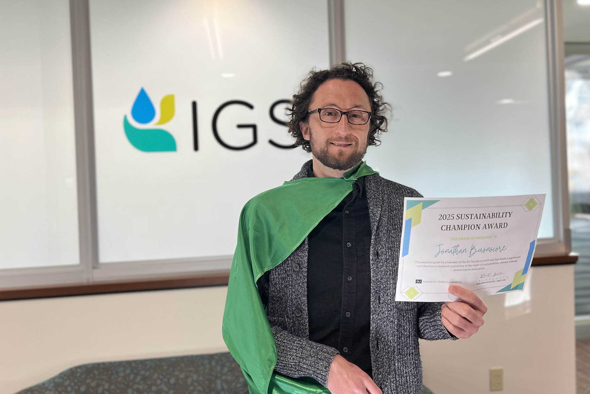 Photo: A white man poses with his certificate for a student award.