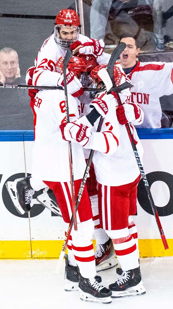 Photo: Members of the BU Men's hockey team embracing in a celebration on the ice