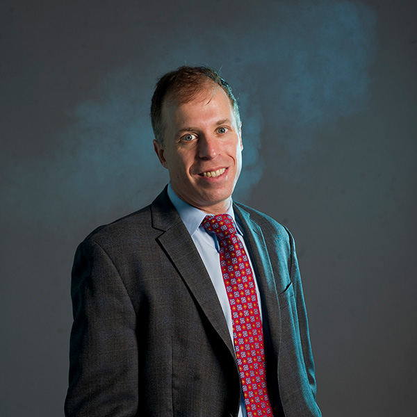 Photo: A man in a suit poses for a formal portrait