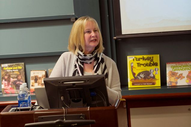 Photo: Evelyn Ford-Connors standing behind a podium while leading a class