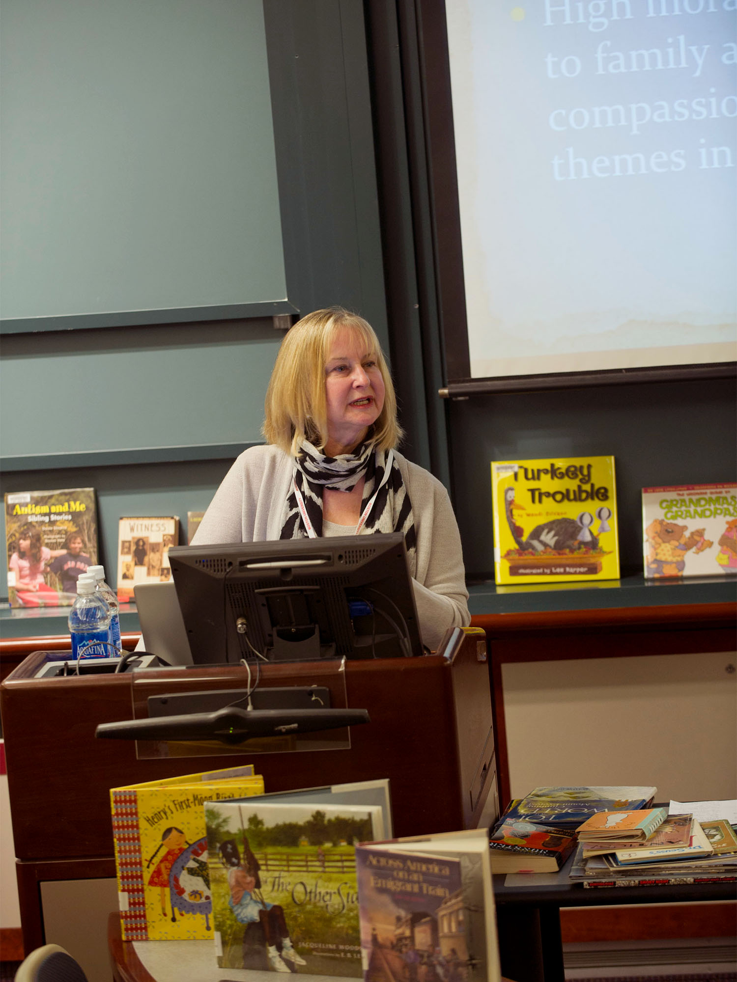 Photo: Evelyn Ford-Connors standing behind a podium while leading a class