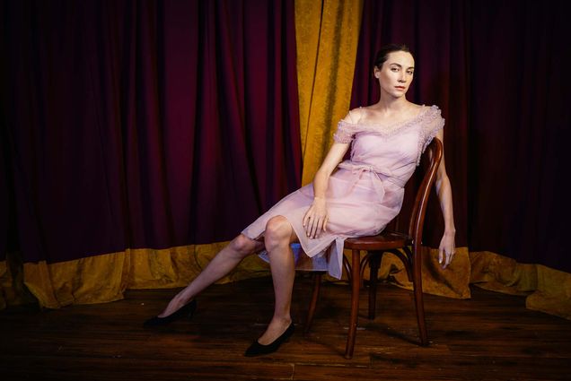 Photo: A tall woman draped artistically over a chair in a pink chiffon gown.