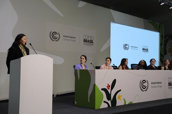 Photo: A young woman moderates a panel.