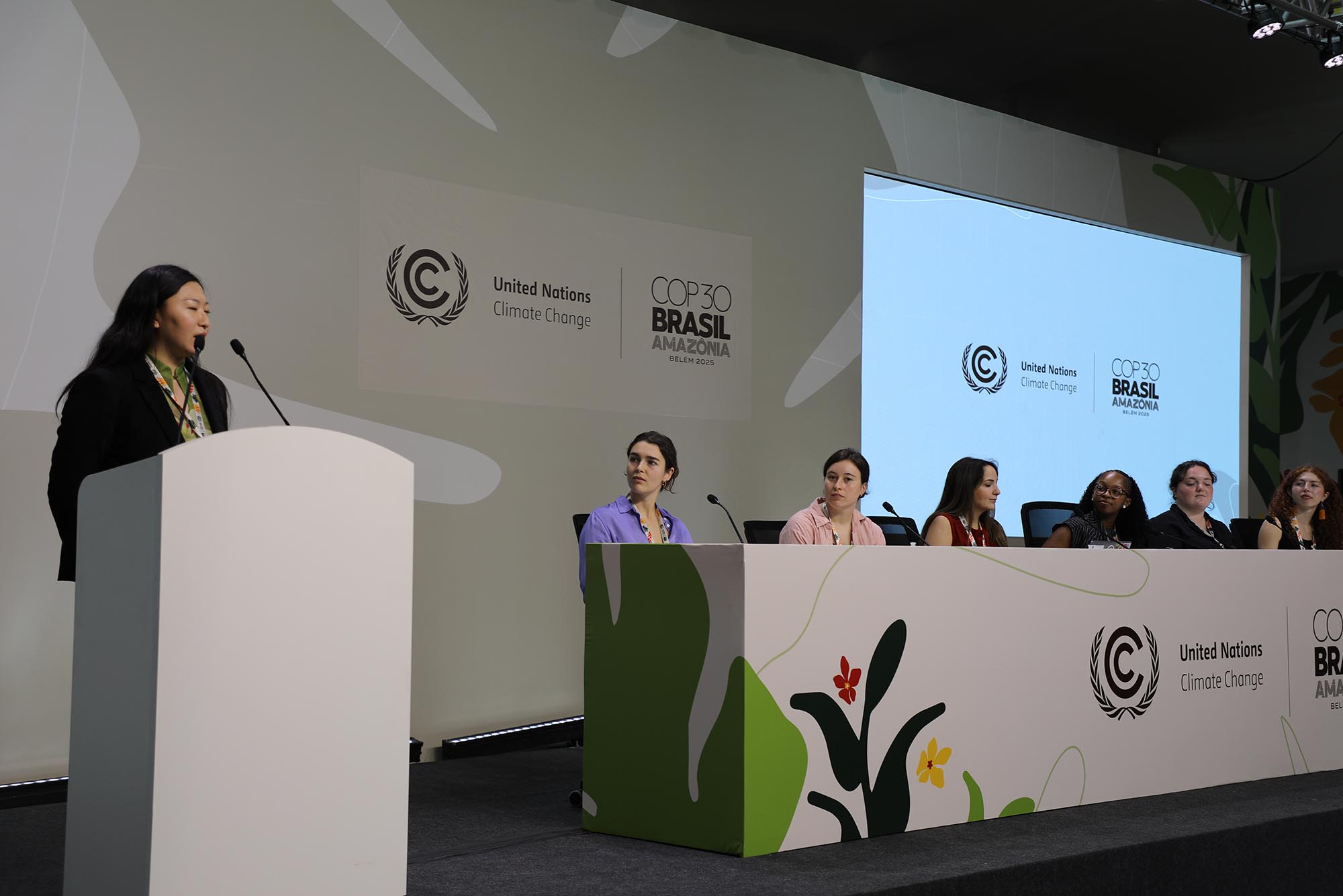 Photo: A young woman moderates a panel.