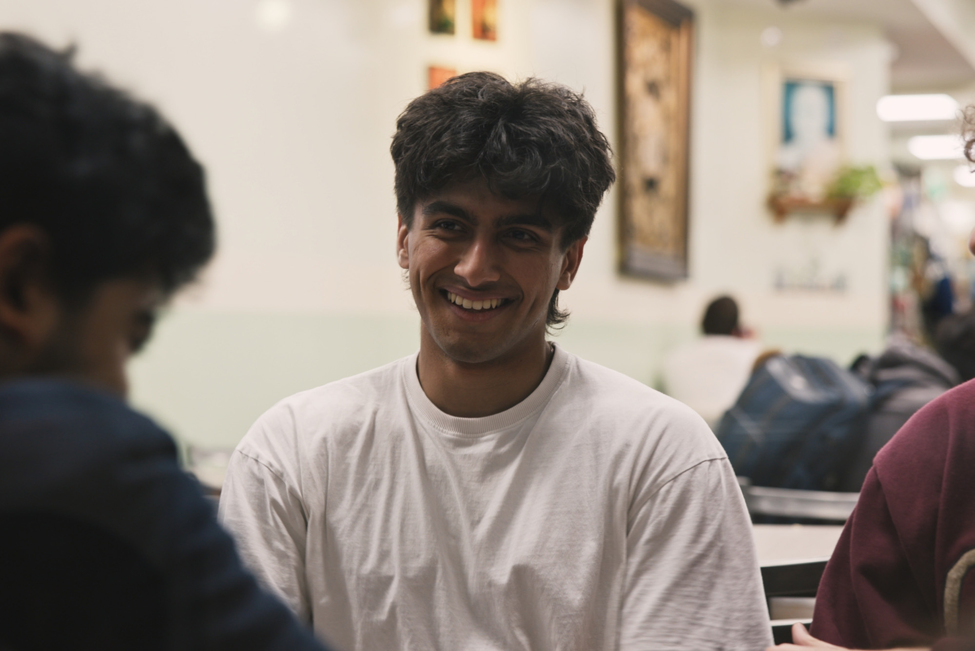 Photo: Three BU students sitting at a table and laughing together