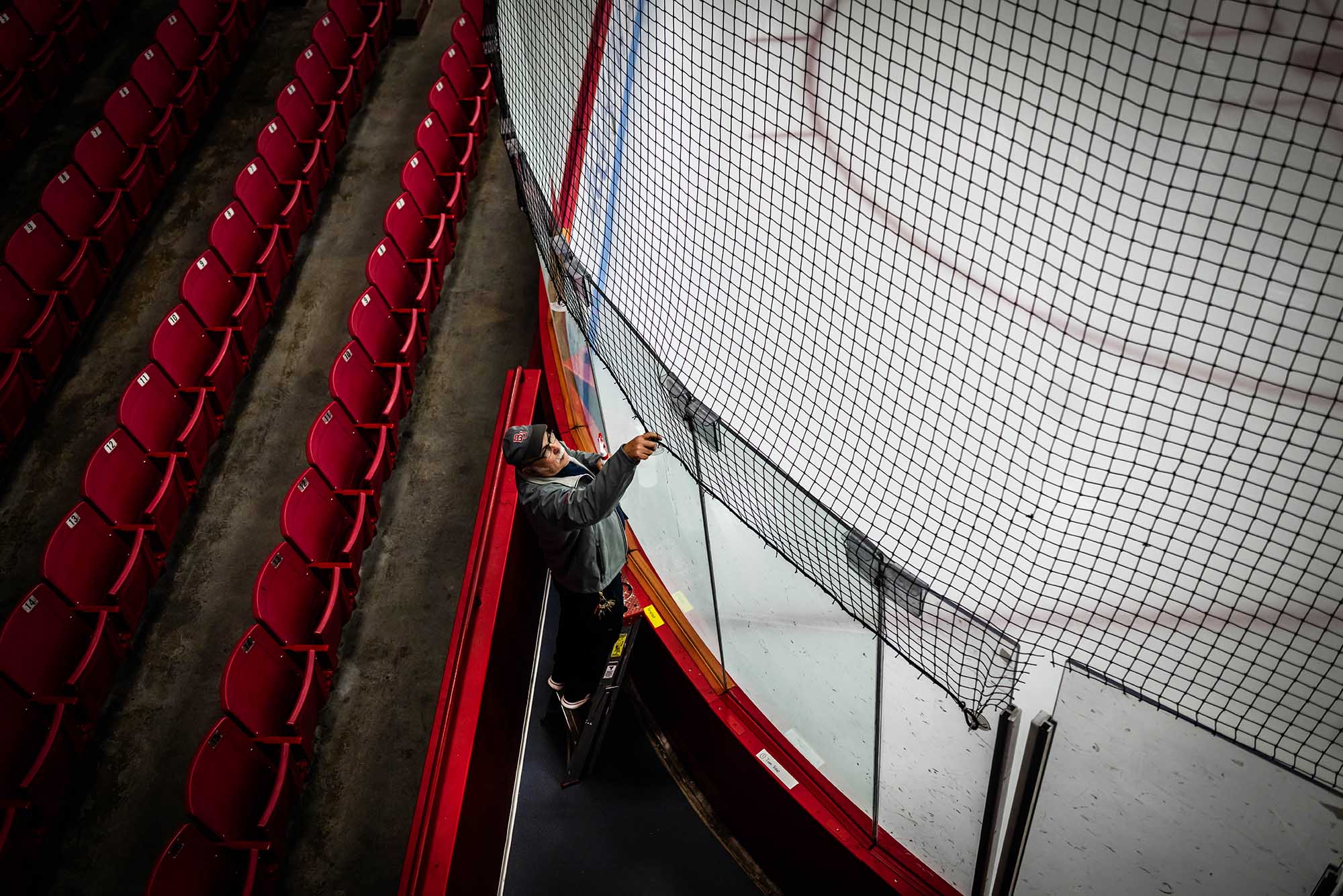 Photo: Joe Melo attaches the net in preparation for the 47th Women’s Beanpot tournament at Walter Brown Arena