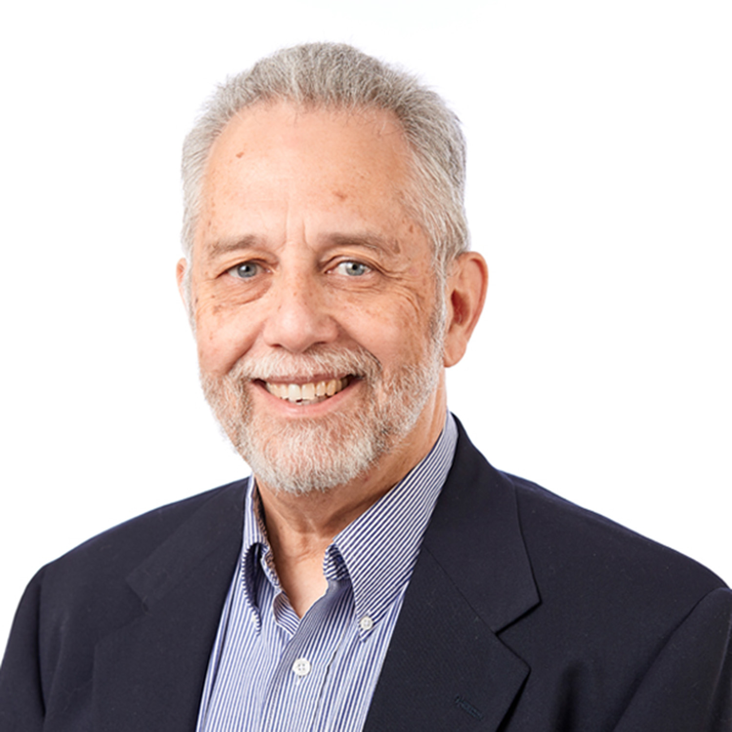 Photo: A headshot of a man with gray hair smiling
