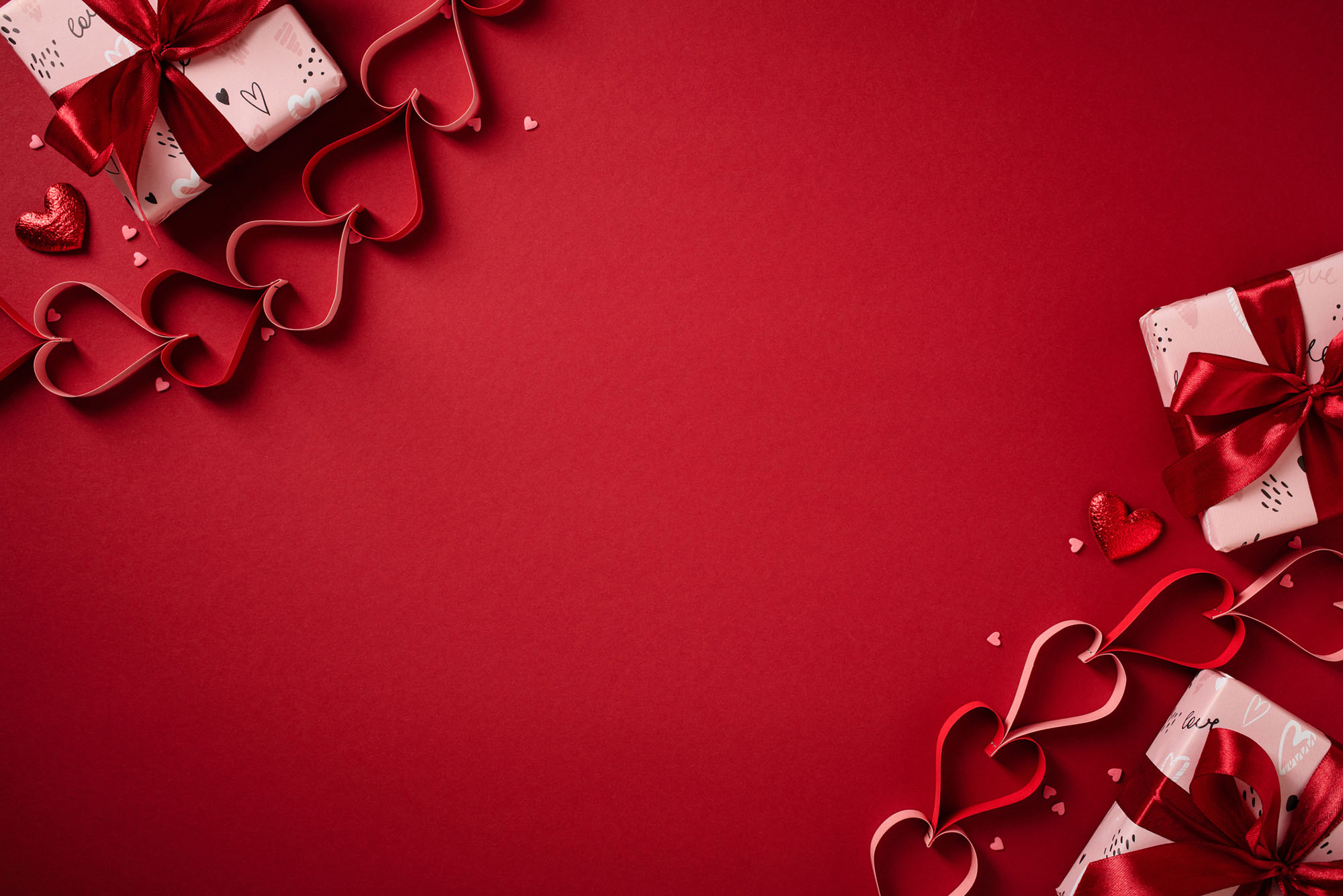 Photo: Valentine's Day frame with gift boxes and paper hearts on a red background
