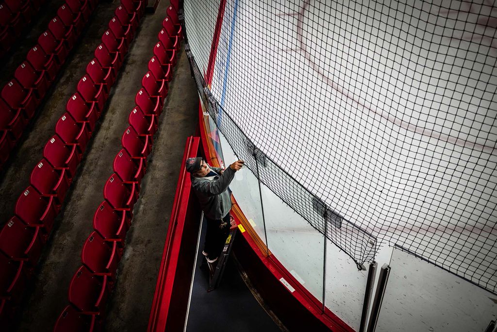 Photo: Joe Melo attaches the net in preparation for the 47th Women’s Beanpot tournament at Walter Brown Arena