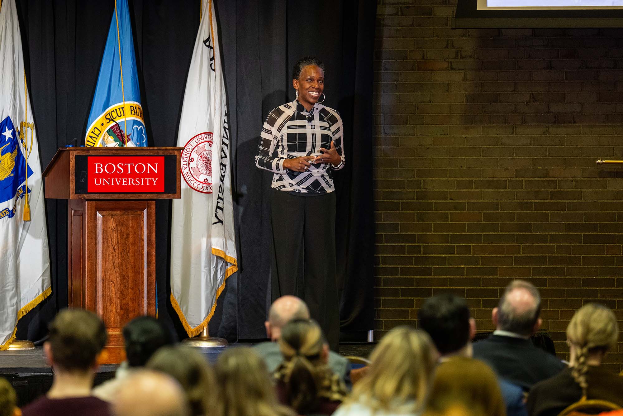 Photo: Melissa Gilliam gives a speech in front of a large audience at Boston University