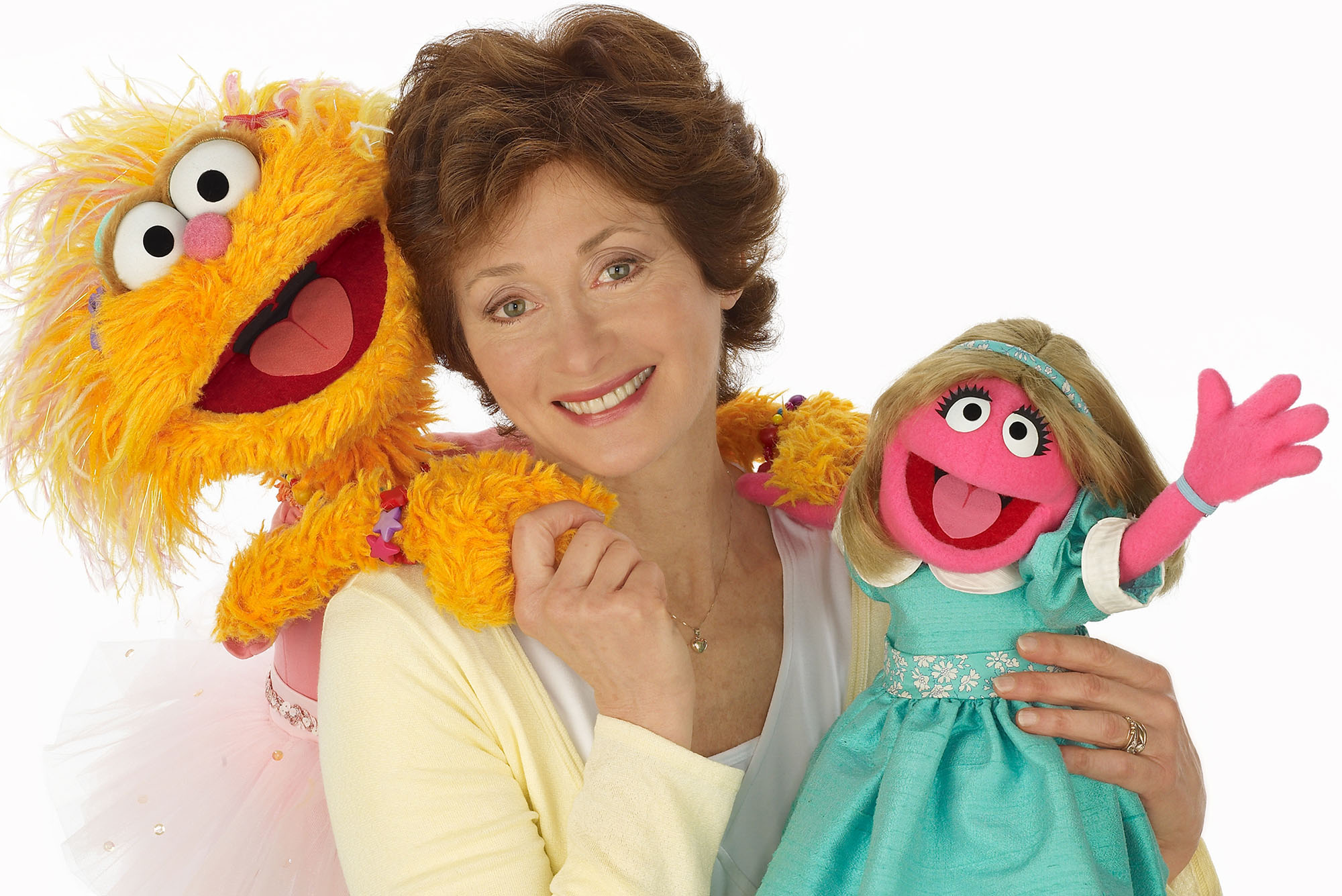 Photo: Fran Brill (CFA’68) holds two of the characters she created: monster Zoe and the little girl Prairie Dawn