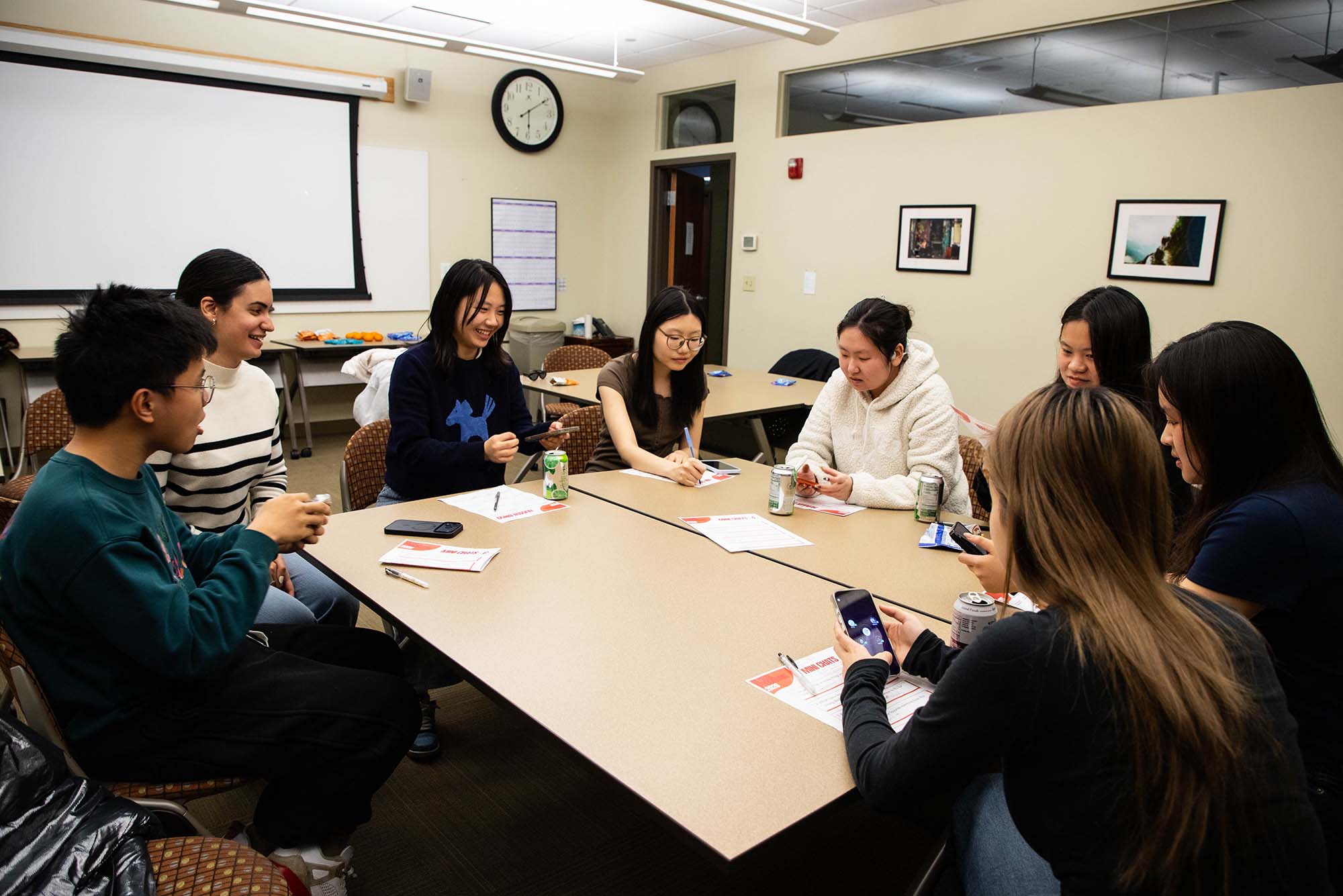 Photo: A group of students sit around a common room table to discuss study abroad at BU