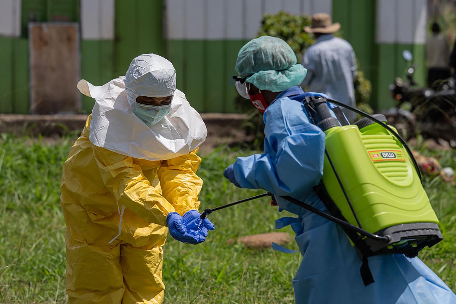 Photo: A Red Cross worker disinfects a fellow Red Cross worker as the work in Congo after an Ebola outbreak