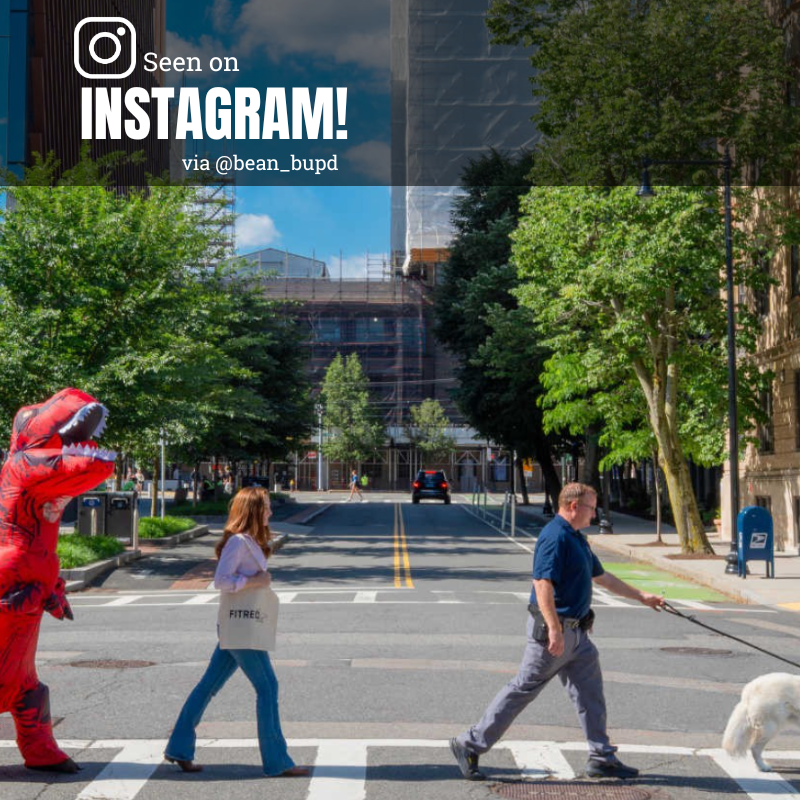 Photo: People crossing the street with a dog, while a person in a dinosaur suit follows close behind. Text overlay reads "Seen on Instagram via @bean_bupd"