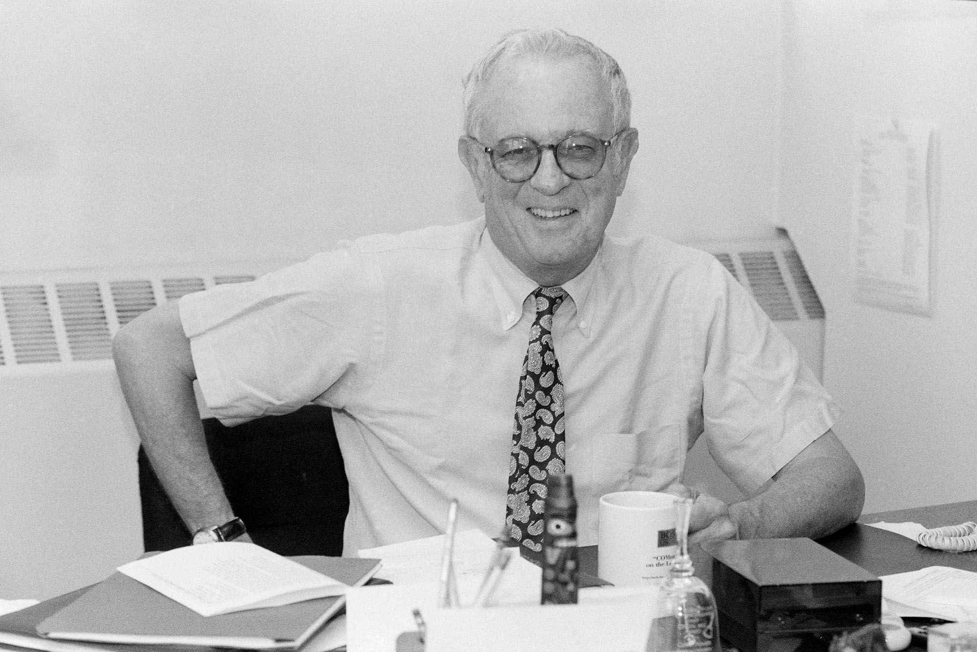 Photo of Gerald Powers sitting at his desk