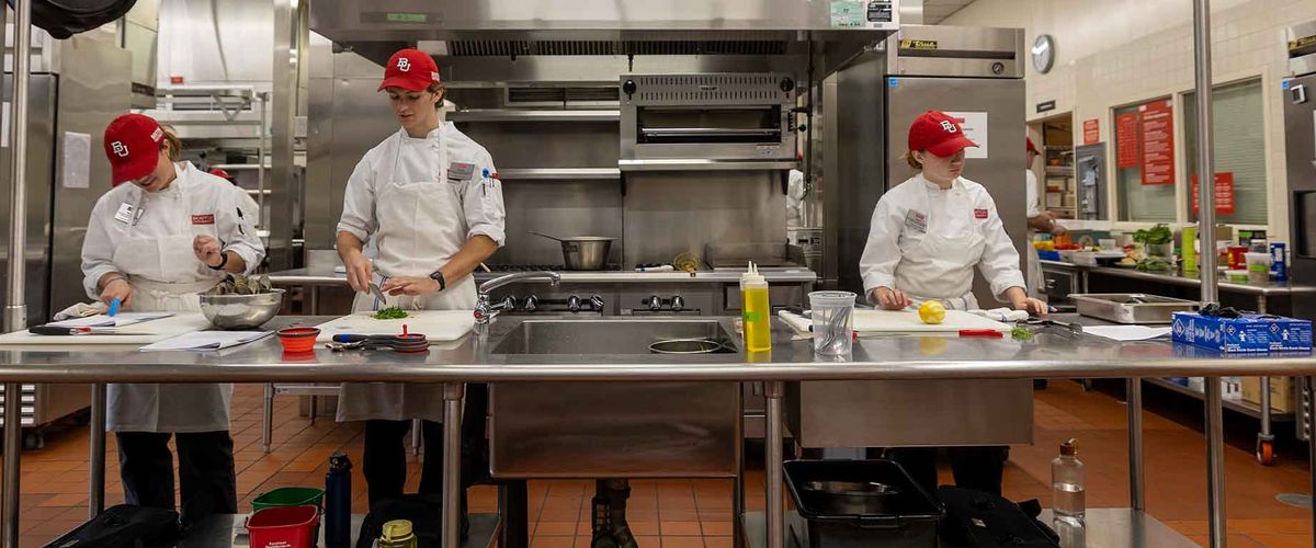 Boston University Food & Wine students preparing ingredients in a kitchen