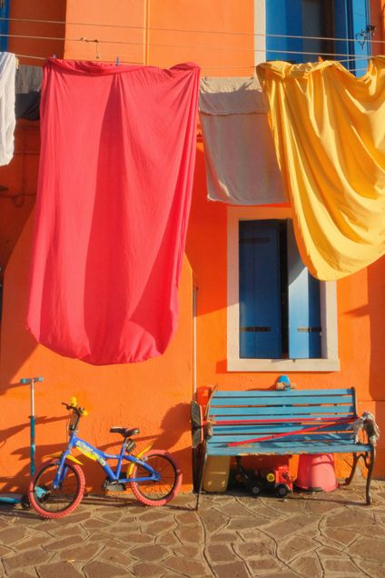 Finalist 2025 GP Photo Contest red and yellow sheets against an orange building in Italy