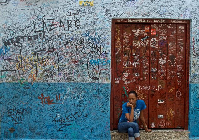 2018 GP Photo Contest Finalist woman siting in a doorway of a building covered in graffetti