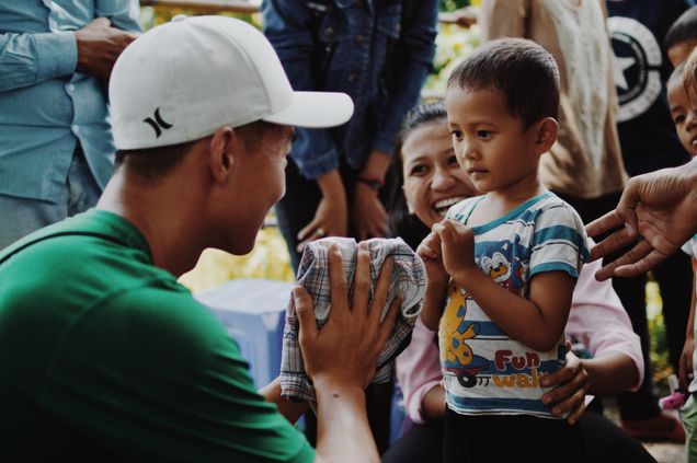 2016 GP Photo Contest Finalist man looking at a small boy and his smiling mother in cambodia