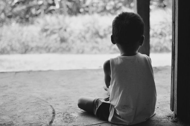 2016 GP Photo Contest Finalist small child sitting in a doorway with his back to the camers looking outside in cambodia