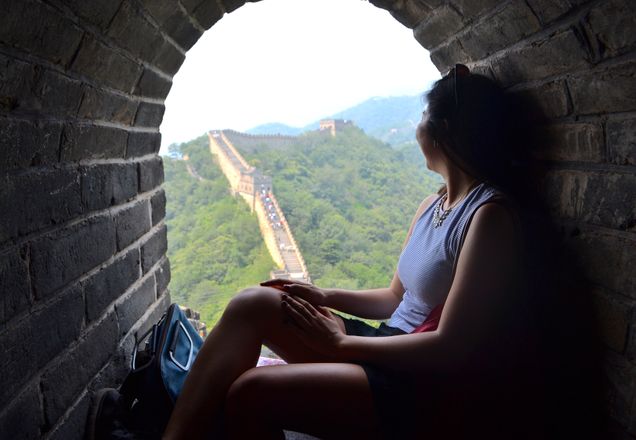 2015 GP Photo Contest Finalist woman sitting in a window along the great wall of china looking at the wall path
