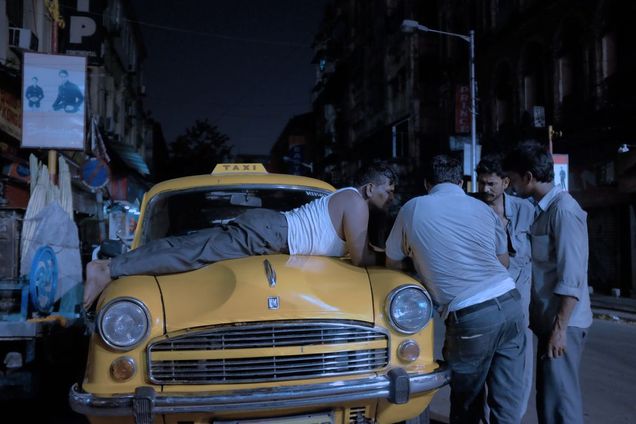2016 GP Photo Contest 2nd place winner man lying on the hood of a taxi cab with several other men gatherd around in India