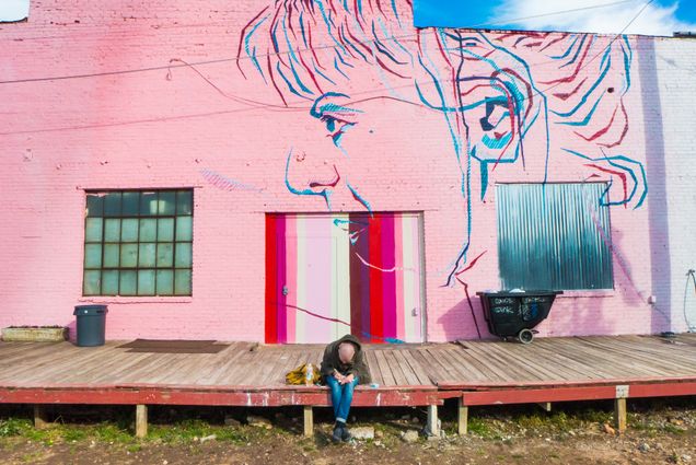 2021 GP photo contest finalist man sitting on loading dock with a pink mural on tha wall behind him
