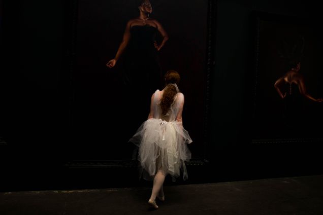 2018 GP Photo Contest Finalist ballet dancer in a white ephmeral costume against a black backround with black dancers obsured in the background