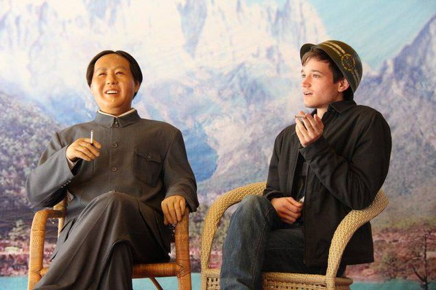 2013 GP Photo Contest Finalist young man siting in a chair next to a manaquin of Chairman Mao pretending he is talking with him