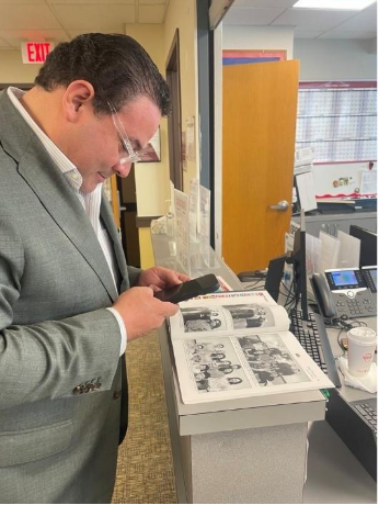 Dr. Pablo Aranibar (MET ’03), looking at a yearbook at CELOP during a visit