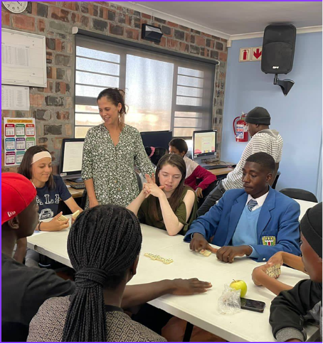 Violet Barton (center, seated at table) volunteering in Cape Town.