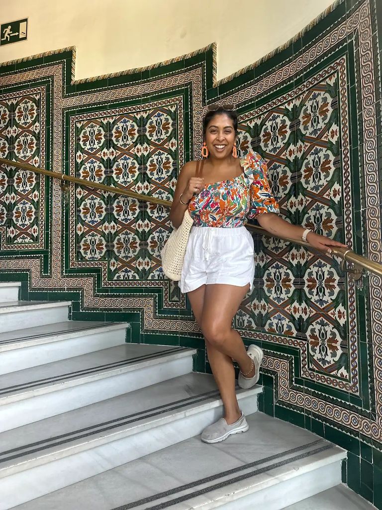 Aparna standing in front of a mosaic wall in Madrid