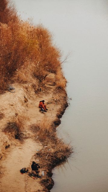 Two men fishing along a muddy riverbank in Atyrau Kazakhstan.2026 GP Photo Contest finalist