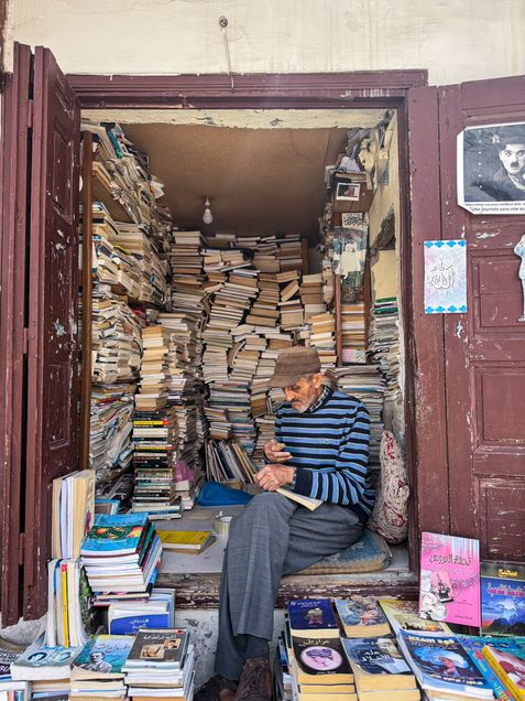 Librarian sitting in libray stall on street in Rabat Morocco. 2026 GP Photo Contest Finalist