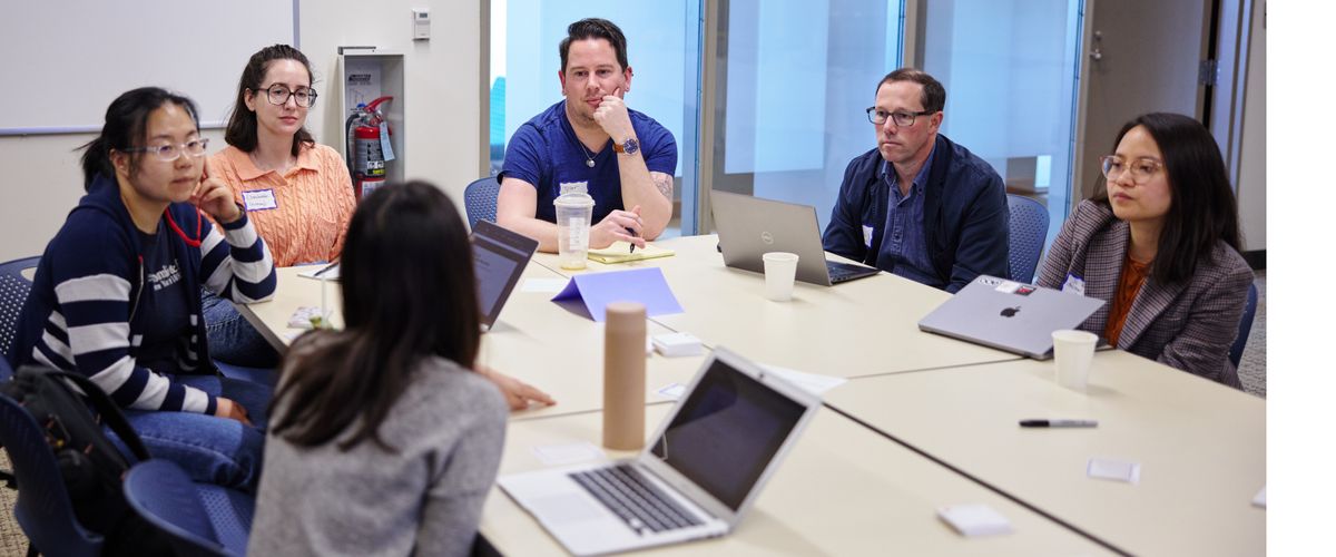 Graduate students participating in a career development workshop discuss with each other.