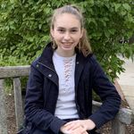Undergraduate student, Rebecca Kielar, sitting on park bench, smiling.