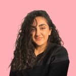 Headshot photograph of Tina Barouti, PhD. Dr Barouti wears all black in front of a solid pink background.