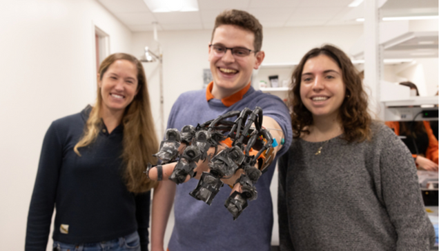 three students showing a soft robotics globe