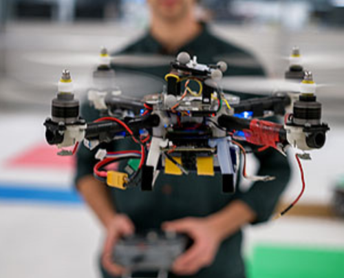 student flying a drone in a lab