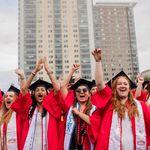 Photo: Students in red graduation gowns cheering during BU's Commencement ceremony
