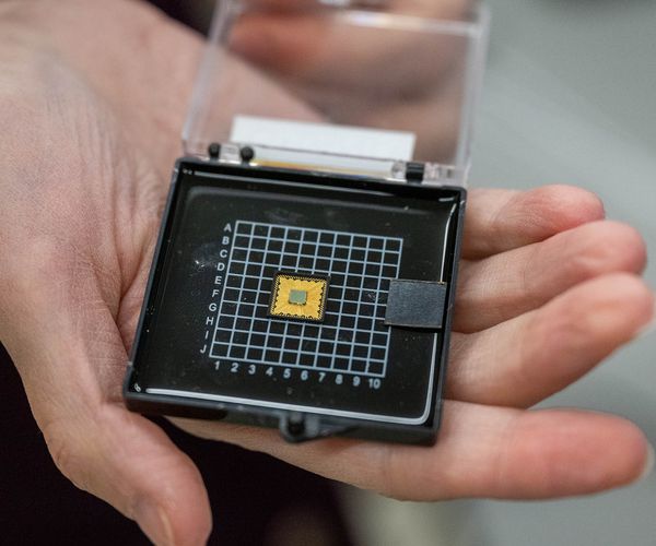 Photo: A hand holding a case with a small engineering chip inside.