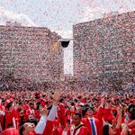 Photo: A wide shot of BU's 153rd commencement as confetti flys in the air. A lone grad hat hovers in the middle of the sky, amidst the celebrations
