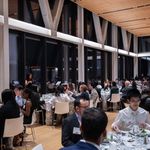Photo: A room filled with many tables and a speaker up front